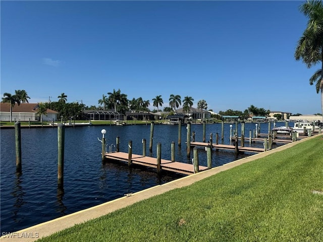 dock area with a water view and a yard