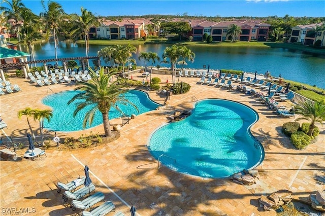 community pool featuring a residential view, a patio area, and a water view