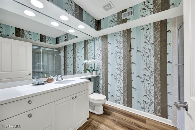 full bath with toilet, visible vents, vanity, a stall shower, and wallpapered walls