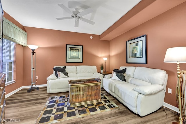 living room with wood finished floors, a ceiling fan, and baseboards