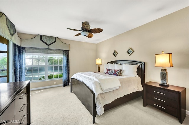 bedroom featuring light colored carpet, ceiling fan, baseboards, and multiple windows