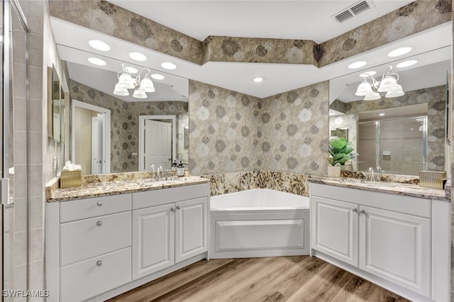 bathroom with wallpapered walls, a stall shower, visible vents, wood finished floors, and a chandelier