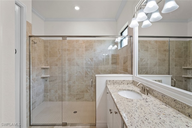 bathroom with a shower with shower door, vanity, and ornamental molding