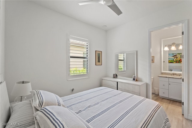 bedroom featuring ceiling fan, light hardwood / wood-style floors, and connected bathroom