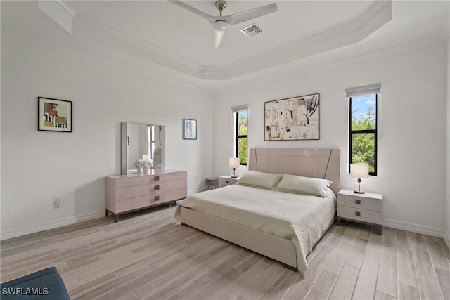 bedroom with ceiling fan, a raised ceiling, light hardwood / wood-style flooring, and crown molding