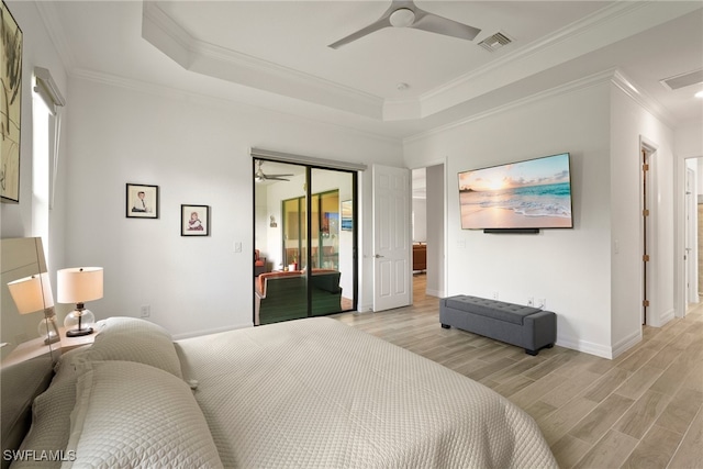 bedroom featuring ceiling fan, a raised ceiling, and light wood-type flooring