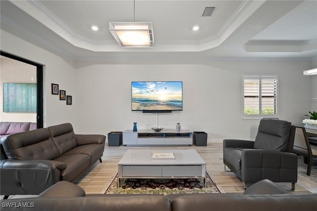 living room with crown molding, a tray ceiling, and light hardwood / wood-style floors