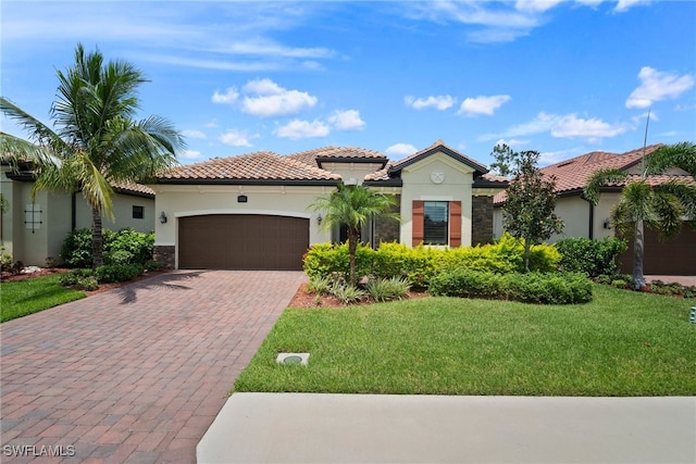 mediterranean / spanish house featuring a garage and a front lawn