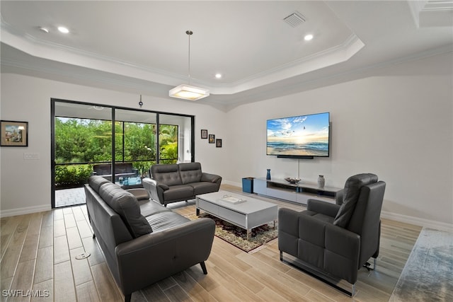 living room with a raised ceiling, light hardwood / wood-style floors, and ornamental molding