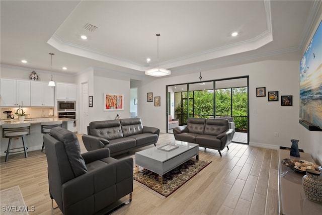 living room with a raised ceiling, light hardwood / wood-style floors, and crown molding