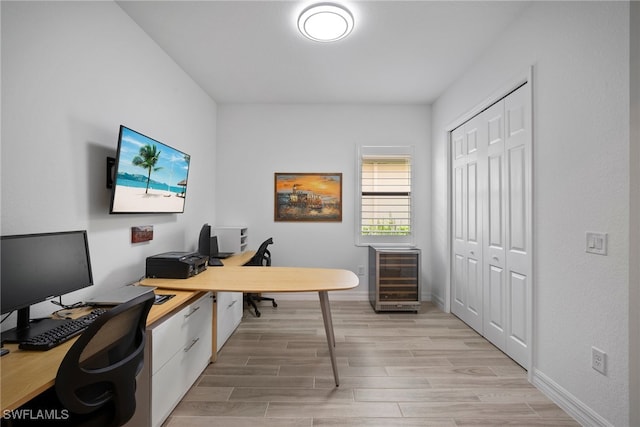 office space with beverage cooler and light hardwood / wood-style flooring