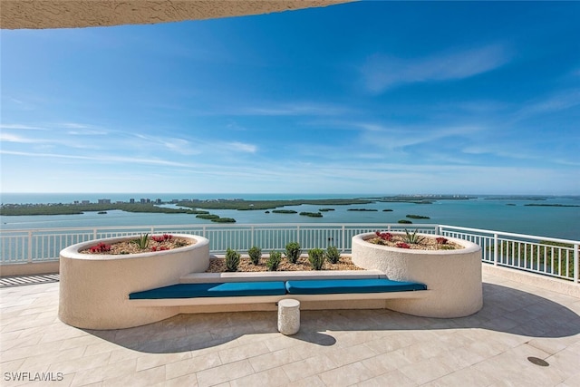 view of patio / terrace with a water view and fence