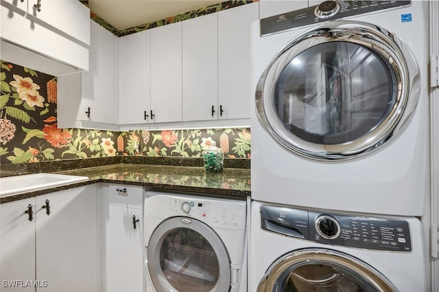 clothes washing area featuring cabinet space and stacked washer / drying machine