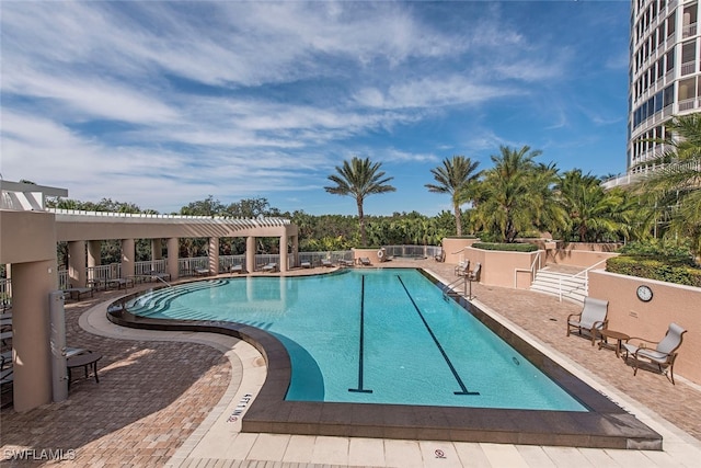 pool featuring a patio area, fence, and a pergola