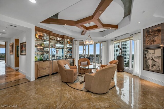 kitchen with a kitchen island with sink, gray cabinetry, a sink, a kitchen breakfast bar, and light stone countertops