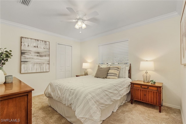 carpeted bedroom featuring a closet, ceiling fan, and crown molding