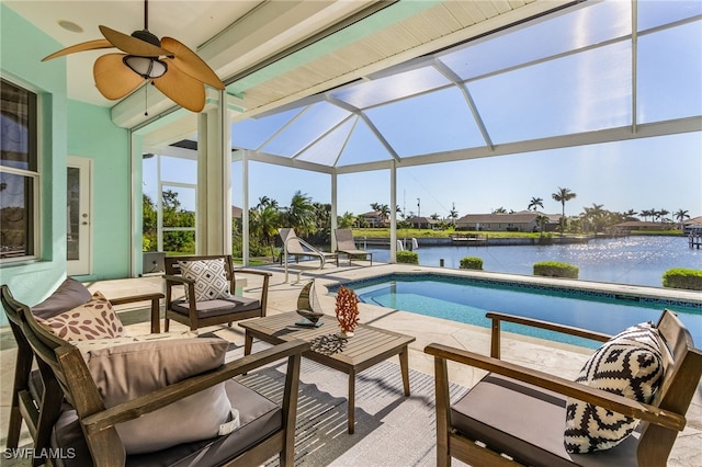 view of pool with glass enclosure, an outdoor living space, ceiling fan, a water view, and a patio