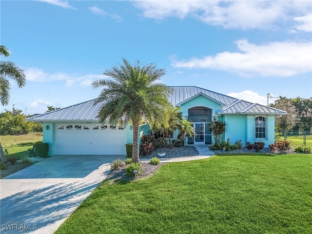 ranch-style home with stucco siding, a front lawn, driveway, a standing seam roof, and metal roof