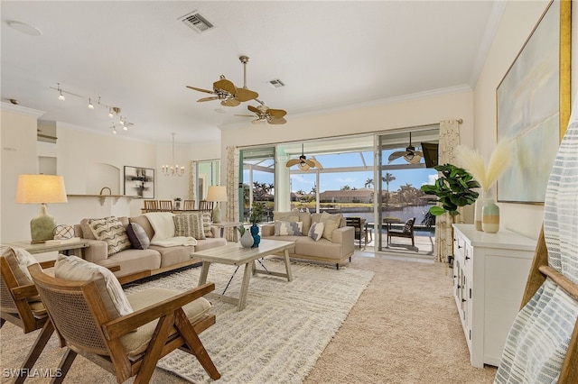 living room with crown molding, ceiling fan with notable chandelier, and light colored carpet