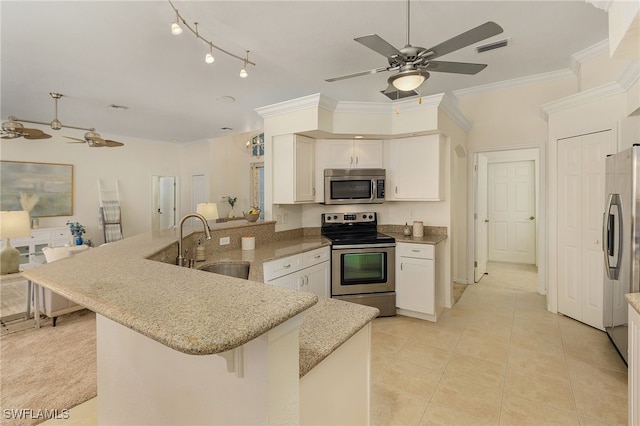 kitchen featuring appliances with stainless steel finishes, sink, kitchen peninsula, ornamental molding, and a breakfast bar area