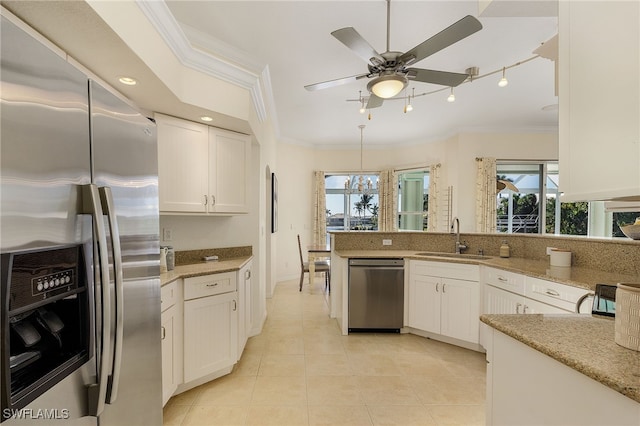 kitchen with white cabinets, stainless steel appliances, sink, light stone counters, and crown molding