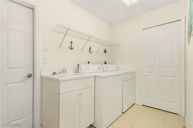 clothes washing area with sink, independent washer and dryer, cabinets, and light tile patterned floors