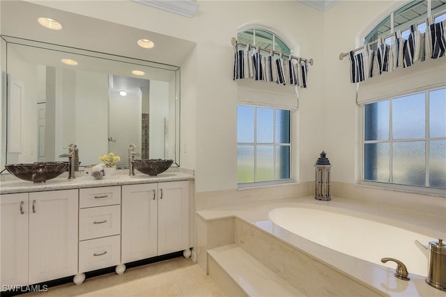 bathroom with a tub, plenty of natural light, tile patterned floors, and vanity