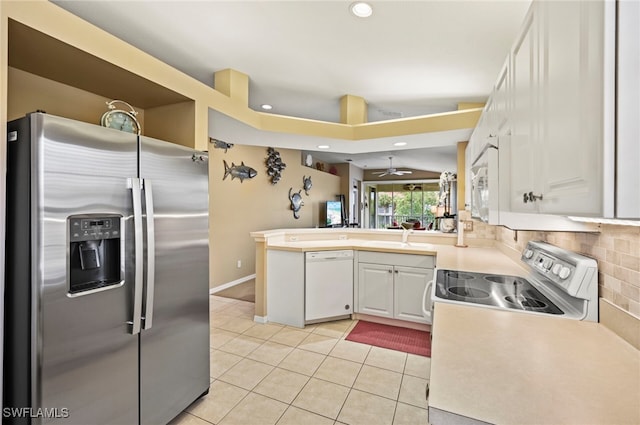 kitchen with tasteful backsplash, light tile patterned floors, kitchen peninsula, stainless steel appliances, and white cabinets