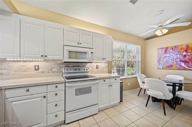 kitchen with white cabinetry, tasteful backsplash, light tile patterned floors, ceiling fan, and white appliances