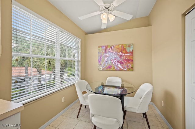 tiled dining space featuring vaulted ceiling, a healthy amount of sunlight, and ceiling fan