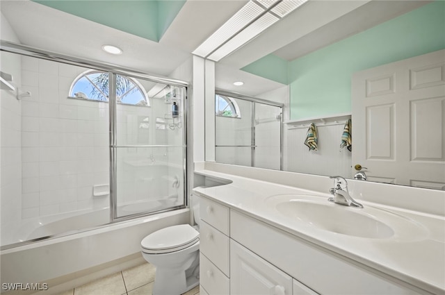 full bathroom featuring toilet, vanity, shower / bath combination with glass door, and tile patterned flooring