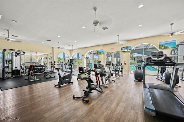 workout area with hardwood / wood-style flooring, ceiling fan, and a textured ceiling