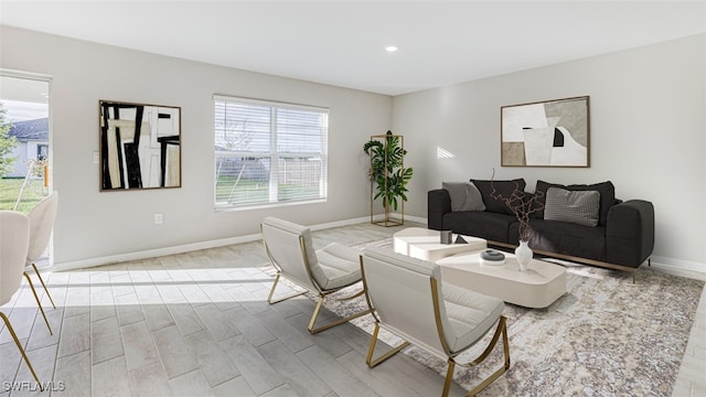 living room with a wealth of natural light and light hardwood / wood-style flooring