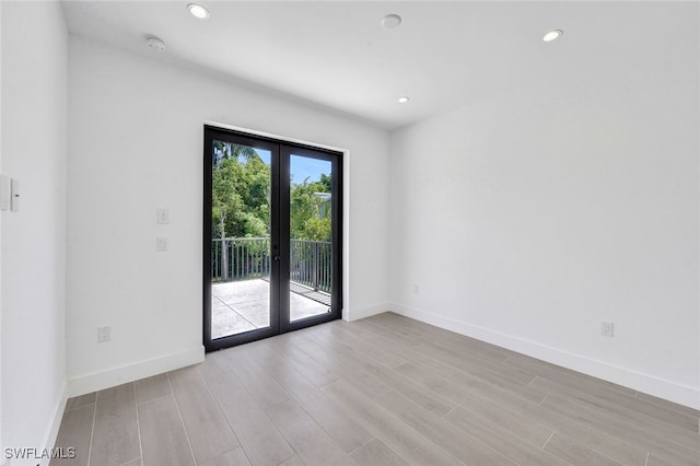 spare room with light wood-type flooring and french doors