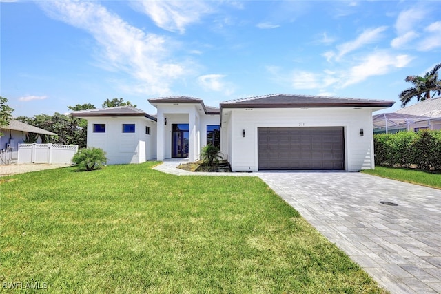 view of front of home with a garage and a front lawn