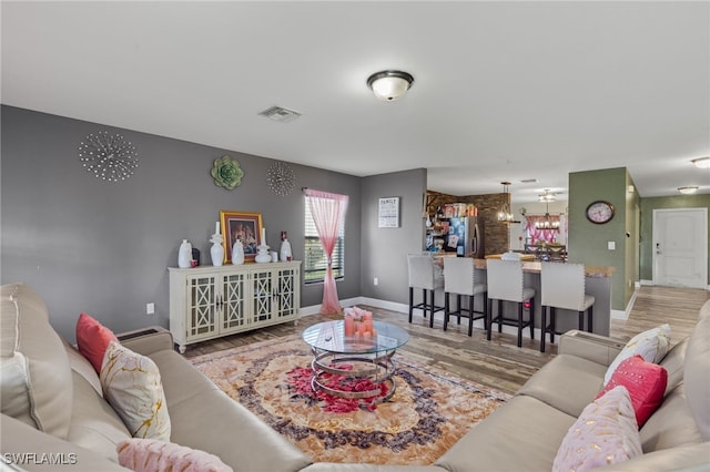 living room featuring a notable chandelier and light hardwood / wood-style floors