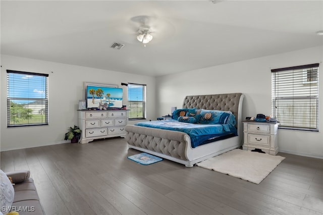 bedroom featuring ceiling fan, multiple windows, and wood-type flooring