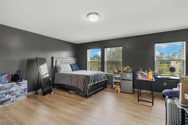 bedroom featuring light hardwood / wood-style floors and stainless steel refrigerator