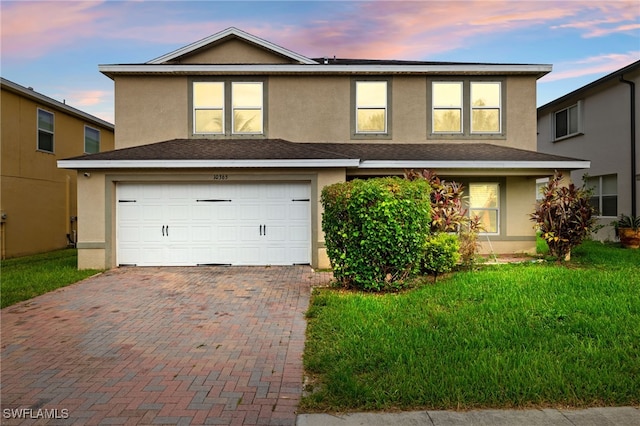 view of front property with a garage and a lawn