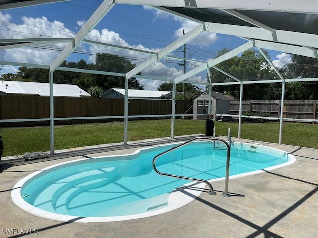 view of swimming pool featuring a lawn, a lanai, a patio, and a shed