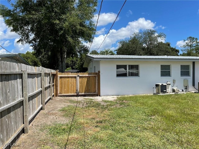 rear view of property with a yard and central AC unit