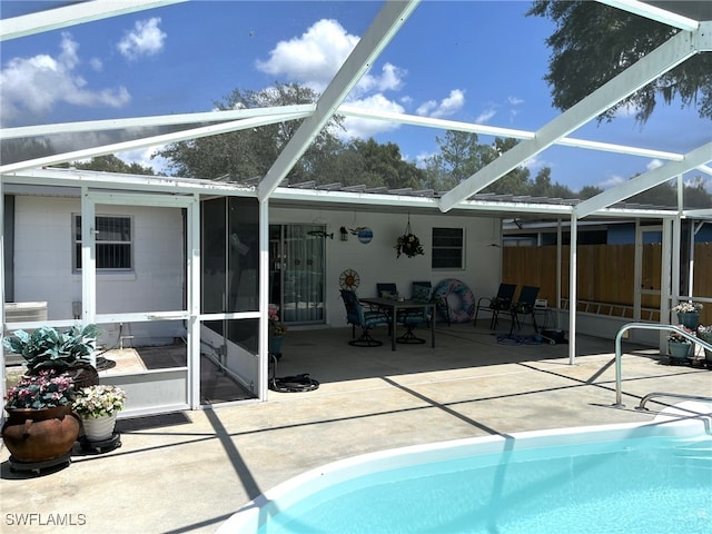 view of pool featuring a patio, glass enclosure, and a sunroom