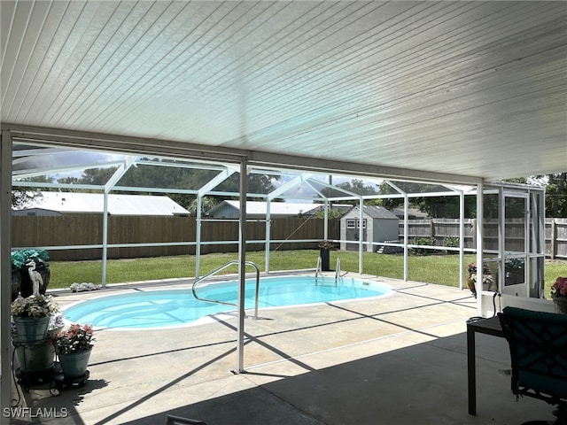 view of pool featuring a storage unit, a yard, a lanai, and a patio