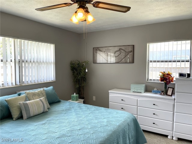 bedroom with a textured ceiling and ceiling fan