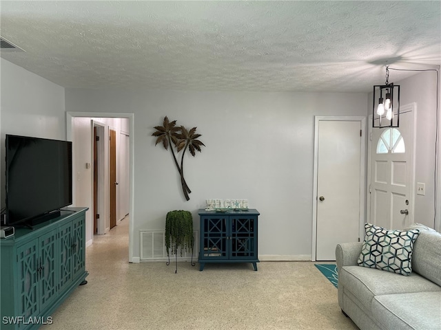 living room featuring a textured ceiling and a chandelier