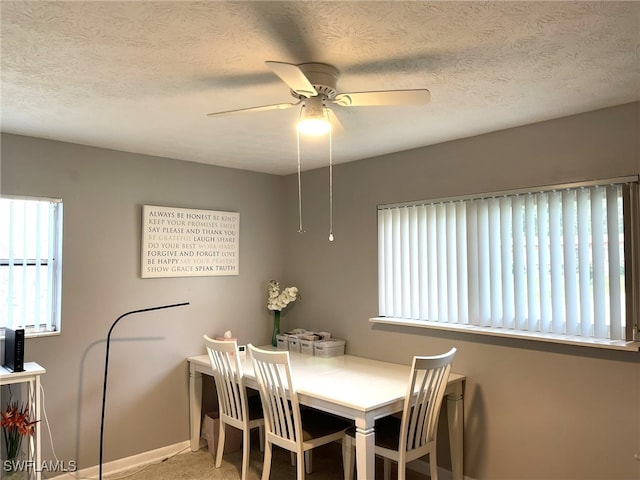 carpeted dining space featuring a textured ceiling and ceiling fan