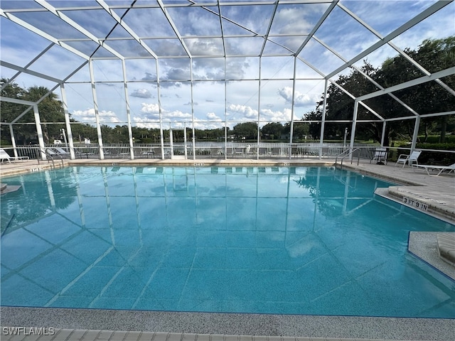 view of swimming pool with glass enclosure and a patio