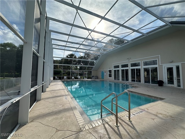 view of swimming pool featuring a patio and glass enclosure