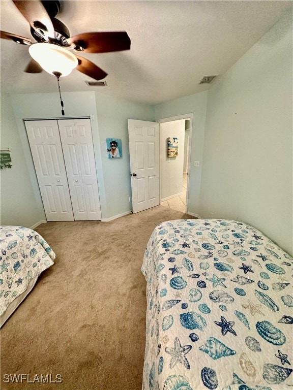 bedroom with ceiling fan, a closet, and light carpet