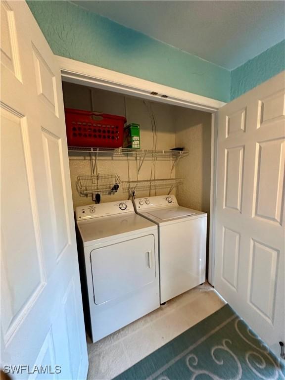 laundry room featuring washer and dryer and light tile patterned flooring